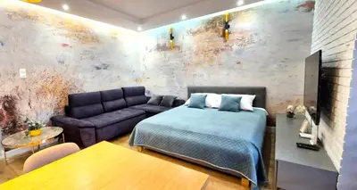 a bedroom with a bed and a couch at LUXURY BLUE CASCADE studio DOWNTOWN balcony in Kraków