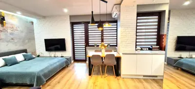 a bedroom with a bed and a table and a kitchen at LUXURY BLUE CASCADE studio DOWNTOWN balcony in Kraków