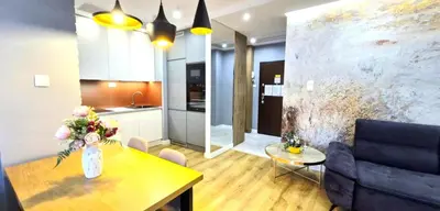 a living room with a table and a kitchen at LUXURY BLUE CASCADE studio DOWNTOWN balcony in Kraków