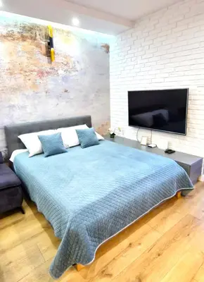 a bedroom with a large bed and a flat screen tv at LUXURY BLUE CASCADE studio DOWNTOWN balcony in Kraków