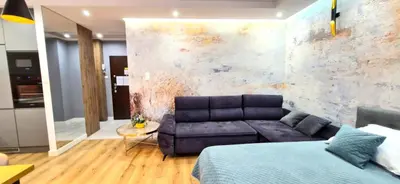 a living room with a couch in front of a wall at LUXURY BLUE CASCADE studio DOWNTOWN balcony in Kraków