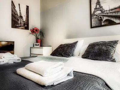 a bedroom with a white bed with towels on it at Apartment next to Wawel Castle, Vistula River & Old Town Cracow in Kraków
