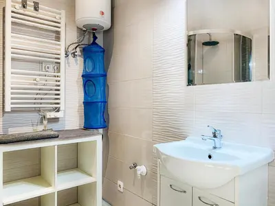 a bathroom with a sink and a blue vase at Apartment next to Wawel Castle, Vistula River & Old Town Cracow in Kraków