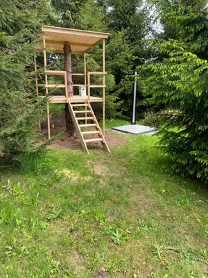 a tree house with a ladder in a field at Lawendowy Domek TP in Sułkowice