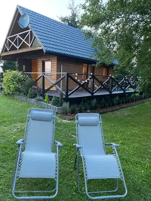 two chairs sitting in the grass in front of a house at Lawendowy Domek TP in Sułkowice