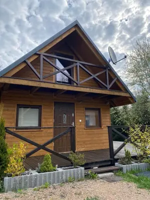 a wooden house with a porch and a satellite at Lawendowy Domek TP in Sułkowice