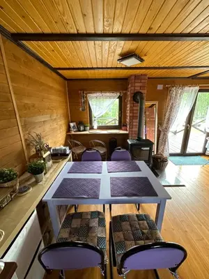 a table and chairs in a room with a stove at Lawendowy Domek TP in Sułkowice