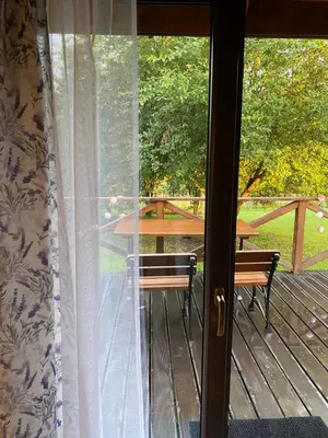 a sliding glass door to a deck with a table at Lawendowy Domek TP in Sułkowice