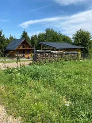 a log cabin with a fence in front of a field at Lawendowy Domek TP in Sułkowice