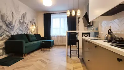 a living room with a green couch and a kitchen at Daszyńskiego 18 by Homeprime in Kraków
