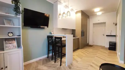 a kitchen with a bar and a tv on the wall at Daszyńskiego 18 by Homeprime in Kraków