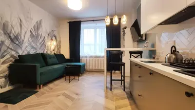 a living room with a green couch and a kitchen at Daszyńskiego 18 by Homeprime in Kraków