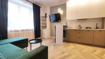 a living room with a couch and a kitchen at Daszyńskiego 18 by Homeprime in Kraków
