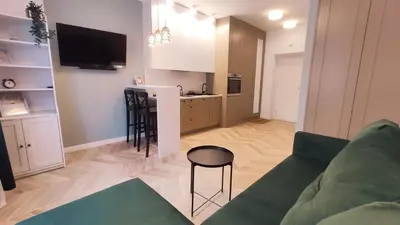 a living room with a couch and a kitchen with a bar at Daszyńskiego 18 by Homeprime in Kraków