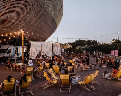 a crowd of people sitting in lawn chairs on a patio at Mogilska Tauron Arena Two Bedroom Apartment in Kraków