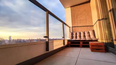 a balcony with a chair on a building with a view at Mogilska Tauron Arena Two Bedroom Apartment in Kraków