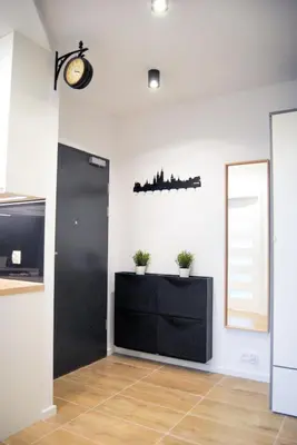 a room with a black cabinet and a mirror at Mogilska Tauron Arena Two Bedroom Apartment in Kraków