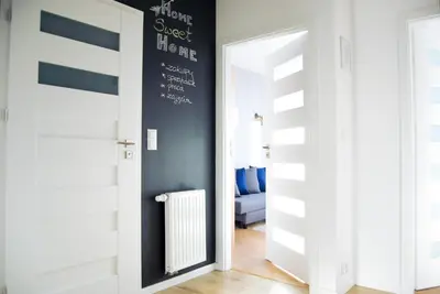 a hallway with an open door with a radiator at Mogilska Tauron Arena Two Bedroom Apartment in Kraków