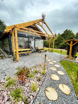 a garden with a wooden pavilion and a bench at Leśne Zacisze Iwkowa in Iwkowa