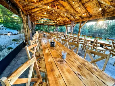 a row of wooden tables and chairs in a restaurant at Leśne Zacisze Iwkowa in Iwkowa