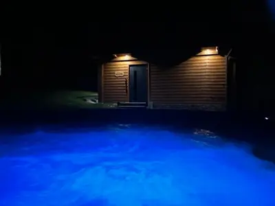 a shed with a door at night with blue lights at Leśne Zacisze Iwkowa in Iwkowa