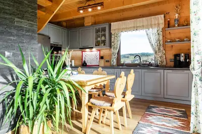a kitchen with a wooden table and chairs in a kitchen at Bacówka na Kubanówce in Rdzawka