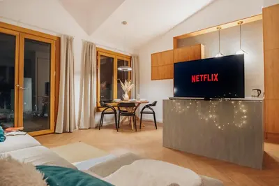 a living room with a television and a table at Kossak 5 Suites in Kraków