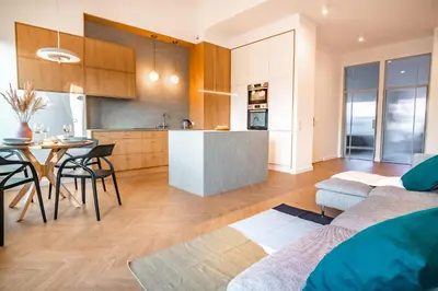 a kitchen and living room with a couch and a table at Kossak 5 Suites in Kraków
