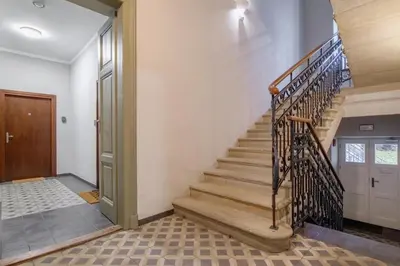 a staircase in a house with a wooden door at Old Town Krakow in Kraków