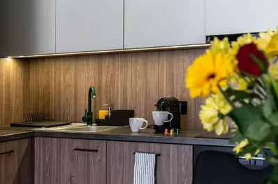 a kitchen counter with a sink and a vase of flowers at Dąbska Street Krakow - Luxury Apartments in Kraków