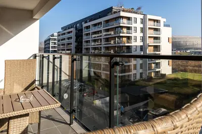 a balcony with a table and a large building at Dąbska Street Krakow - Luxury Apartments in Kraków