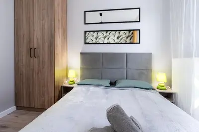 a bedroom with a large bed with two lamps at Dąbska Street Krakow - Luxury Apartments in Kraków