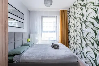 a bedroom with a bed with a stuffed animal on it at Dąbska Street Krakow - Luxury Apartments in Kraków