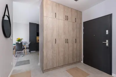 a large wooden cabinet in a room with a table at Dąbska Street Krakow - Luxury Apartments in Kraków