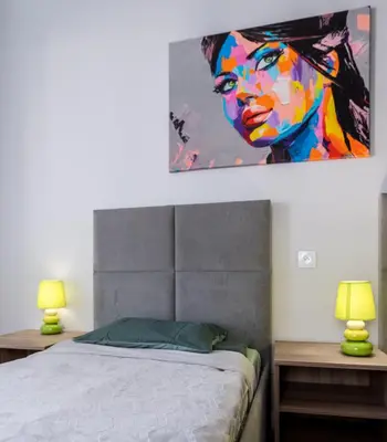 a bedroom with a bed with a painting on the wall at Dąbska Street Krakow - Luxury Apartments in Kraków