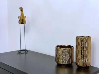 two metal vases sitting on a table with a flower at Rzeszowska 5 Apt. 3 in Kraków