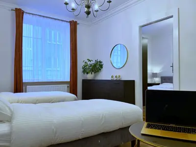 a bedroom with two beds and a laptop on a table at Rzeszowska 5 Apt. 3 in Kraków