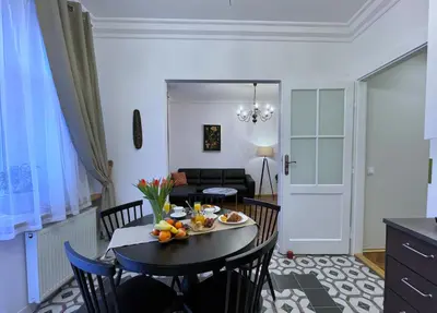 a kitchen and living room with a table and chairs at Rzeszowska 5 Apt. 3 in Kraków