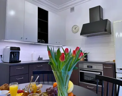 a kitchen with a table with flowers in a vase at Rzeszowska 5 Apt. 3 in Kraków