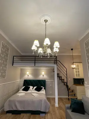 a bedroom with a large bed and a chandelier at Starowiślna Center Apartments in Kraków