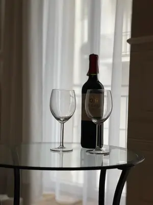 a bottle of wine and two wine glasses on a table at Starowiślna Center Apartments in Kraków