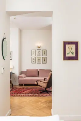 a living room with a pink couch and a table at Classy Old Town Suites - by Upstairs in Kraków