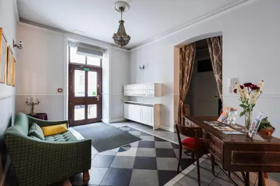 a living room with a couch and a table and a desk at Classy Old Town Suites - by Upstairs in Kraków