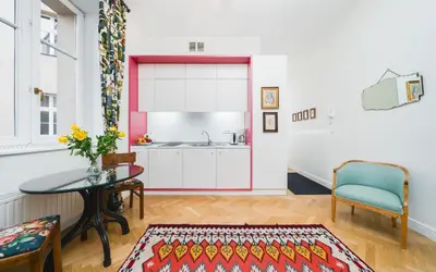 a living room with a table and a kitchen at Classy Old Town Suites - by Upstairs in Kraków
