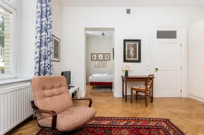 a living room with a chair and a table at Classy Old Town Suites - by Upstairs in Kraków