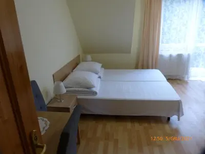 a small bedroom with a bed and a window at Willa Roztoczanka in Rabka