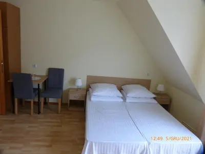 a bedroom with a bed and a table with two chairs at Willa Roztoczanka in Rabka
