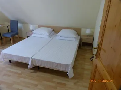 a bedroom with two beds and a blue chair at Willa Roztoczanka in Rabka