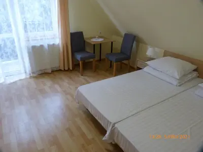 a bedroom with a bed and two chairs and a table at Willa Roztoczanka in Rabka