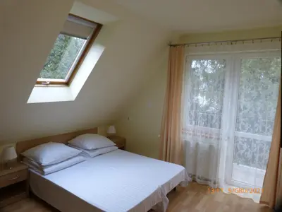 a bedroom with a white bed and a window at Willa Roztoczanka in Rabka